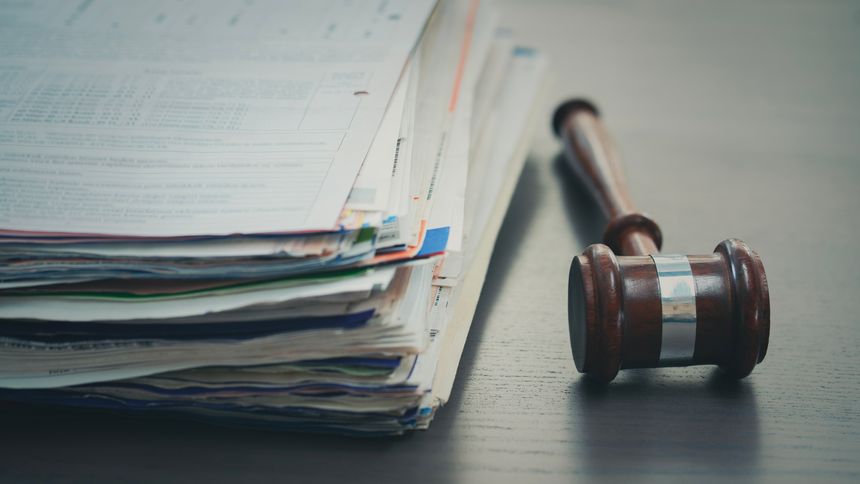 Stack of folders and a judge gavel on a desk